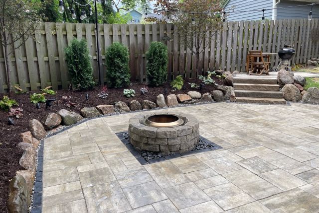 High angle of stone building with potted plants and blooming bushes growing in yard